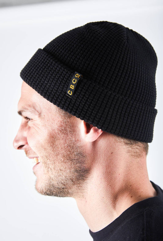 Side view of a Smiling man in a black-colored beanie featuring Billy Bones available at CBCO