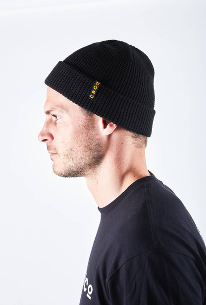Side view of a man in a black-colored beanie featuring Billy Bones available at CBCO